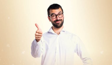 Koyu sarı zemin üzerine başparmak ile gözlüklü yakışıklı adam