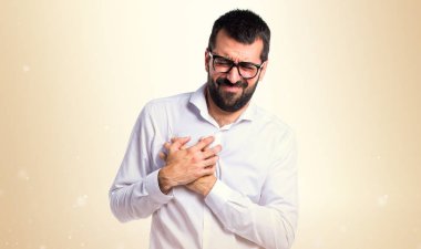 Kalp ağrısı koyu sarı zemin üzerine olan gözlüklü yakışıklı adam