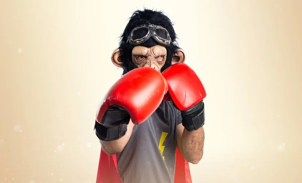 Hombre mono superhéroe con guantes de boxeo sobre fondo ocre —  Fotos de Stock