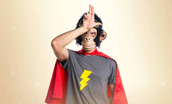 Homem macaco super-herói fazendo gesto estúpido no fundo ocre — Fotografia de Stock