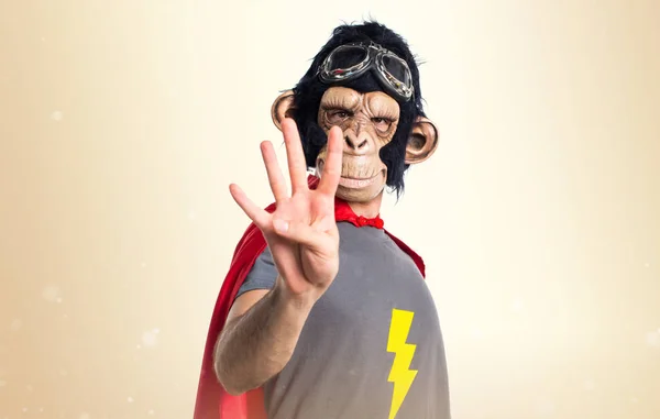 Homem macaco super-herói contando quatro em outro fundo — Fotografia de Stock