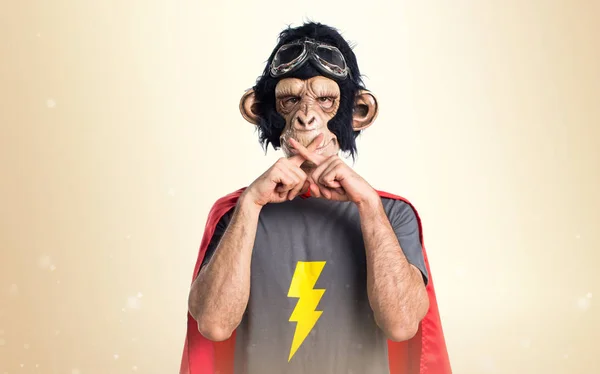 Υπερήρωα μαϊμού άνθρωπος κάνοντας χειρονομία σιωπή σχετικά με φόντο ώχρα — Φωτογραφία Αρχείου