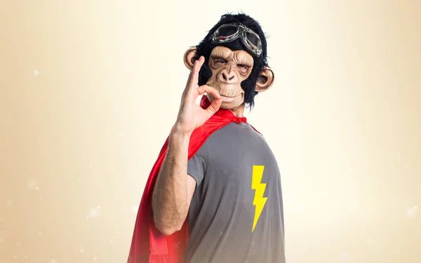 Supereroe scimmia uomo fare OK segno su sfondo ocra — Foto Stock