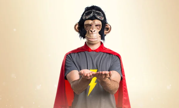 Υπερήρωα μαϊμού άνθρωπος κρατώντας κάτι στο φόντο ώχρα — Φωτογραφία Αρχείου