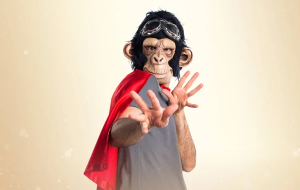 Frightened Superhero monkey man on ocher background