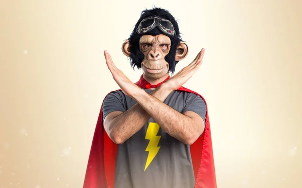 Superhero monkey man doing NO gesture on ocher background