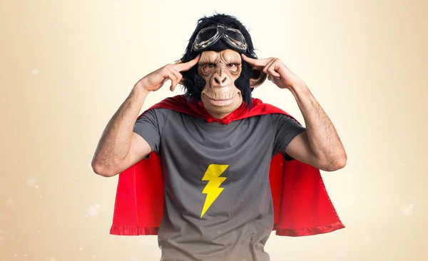 Superhero monkey man thinking on ocher background