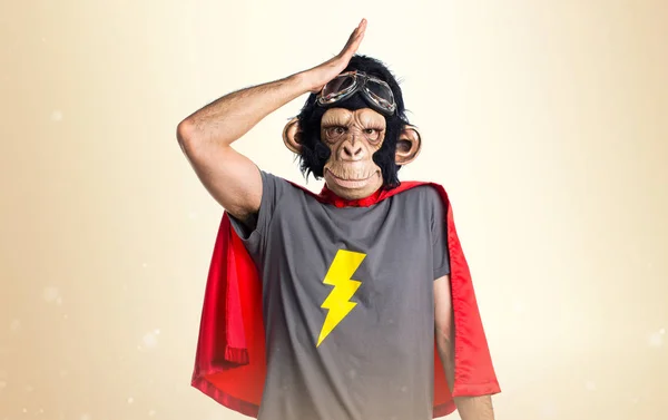 Supereroe scimmia uomo avendo dubbi su sfondo ocra — Foto Stock