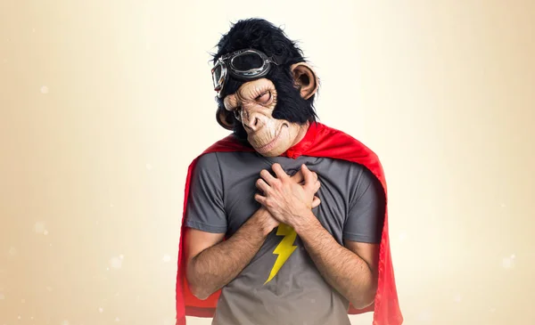 Superhero monkey man with heart pain on ocher background — Stok Foto