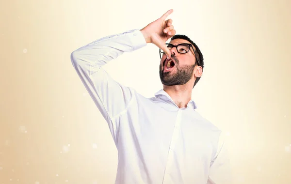 Hombre guapo con gafas haciendo gesto borracho en ocre backgroun —  Fotos de Stock