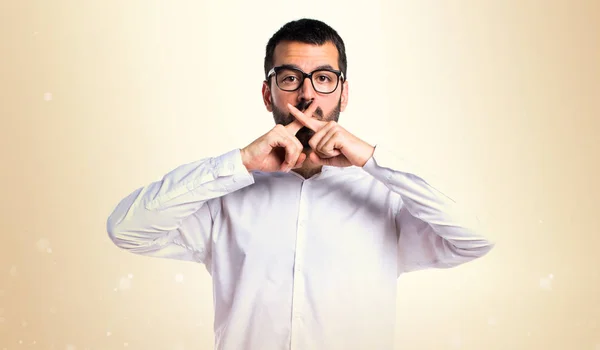 Knappe man met bril maken stilte gebaar op okergeel backgr — Stockfoto