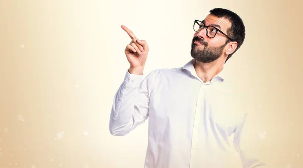 Handsome man with glasses thinking on ocher background — Stock Photo, Image