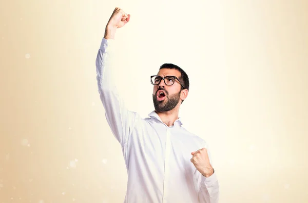 Hombre guapo afortunado con gafas sobre fondo ocre —  Fotos de Stock