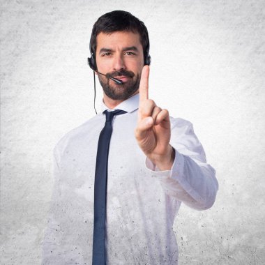 Genç adam bir dokulu arka plan üzerinde sayma bir kulaklık ile