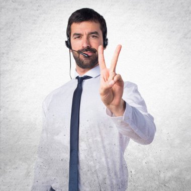 İki dokulu arka plan üzerinde sayma bir kulaklık ile genç adam
