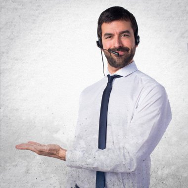 Bir şey üzerinde dokulu backgr sunan bir kulaklık ile genç adam