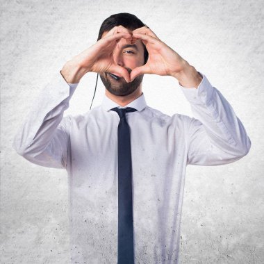 Ellerini bir kalple textur üzerinde yapım bir kulaklık ile genç adam