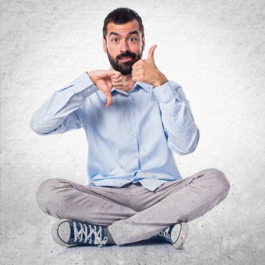 Yakışıklı adam iyi-kötü işareti üzerinde dokulu arka plan yapma