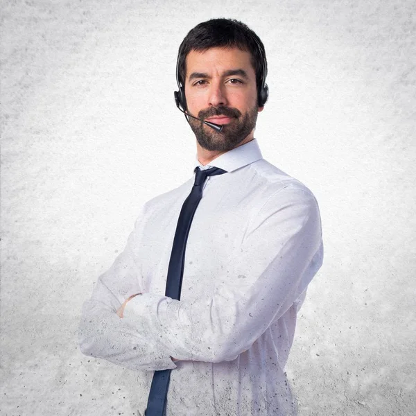 Young man with a headset on textured background — Stock Photo, Image