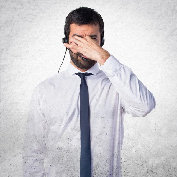 Junger Mann mit Headset macht übel riechende Geste auf Textur — Stockfoto