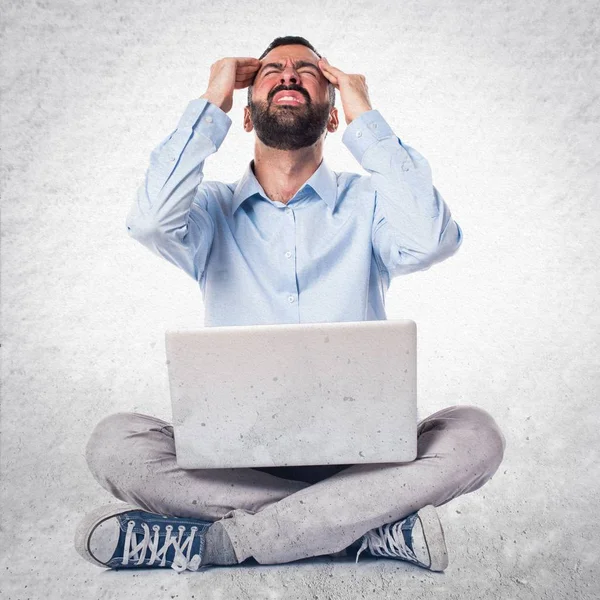 Hombre frustrado con portátil sobre fondo texturizado —  Fotos de Stock