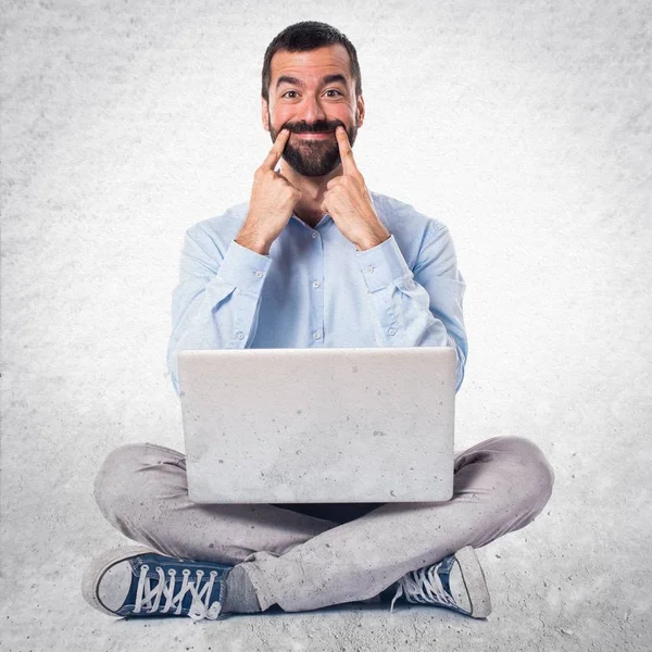 Ευτυχισμένος άνθρωπος με φορητό υπολογιστή σε φόντο με υφή — Φωτογραφία Αρχείου