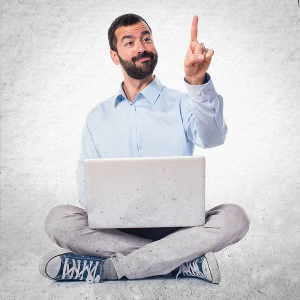 Homem com laptop tocando na tela transparente em backg texturizado — Fotografia de Stock