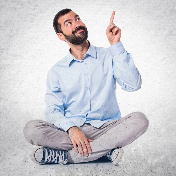 Handsome man pointing up on textured background