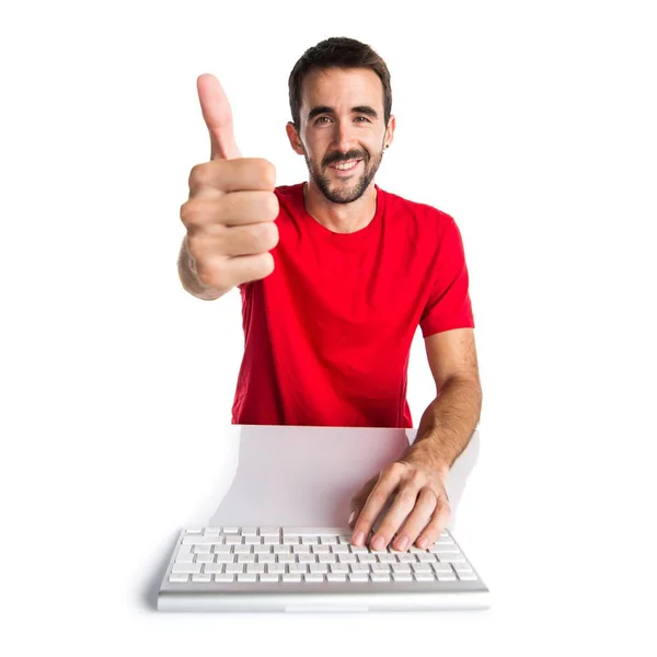 Комп'ютерний технік, що працює зі своєю клавіатурою з великим пальцем вгору — стокове фото