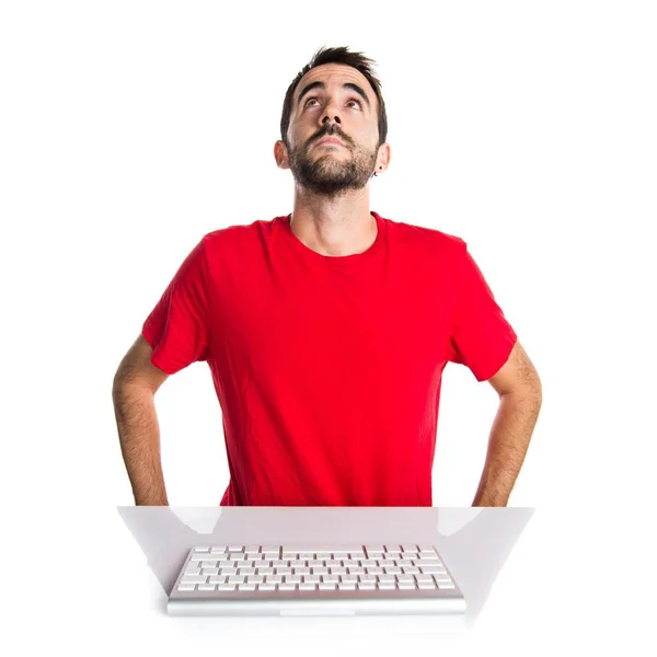 Комп'ютерний технік працює зі своєю клавіатурою, дивлячись вгору — стокове фото