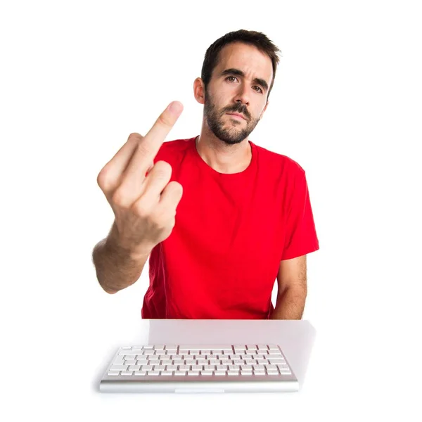 Компьютерный техник, работающий со своей клавиатурой, делая жест рога — стоковое фото