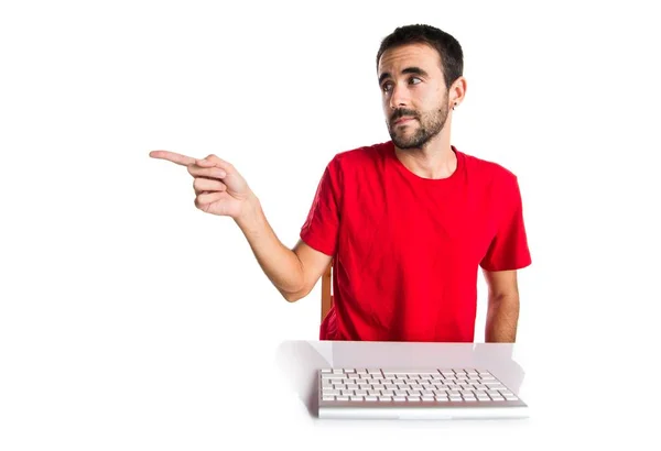 Комп'ютерний технік, який працює зі своєю клавіатурою, вказує на бічну — стокове фото