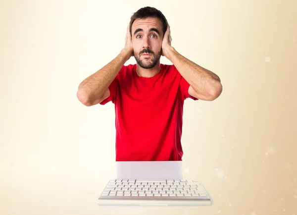 Técnico informático que trabaja con su teclado cubriéndose los oídos —  Fotos de Stock