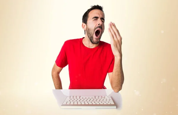 Computertechnicus werken met zijn toetsenbord geeuwen op okergeel b — Stockfoto