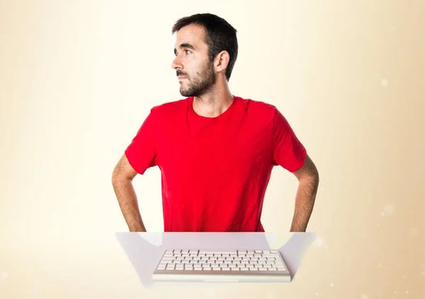 Technicien informatique travaillant avec son clavier regardant latéralement sur — Photo