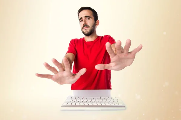 Комп'ютерний технік, що працює зі своєю клавіатурою робить знак зупинки o — стокове фото