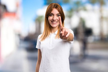 Güzel genç kız bir odaklanmamış arka plan üzerinde sayma