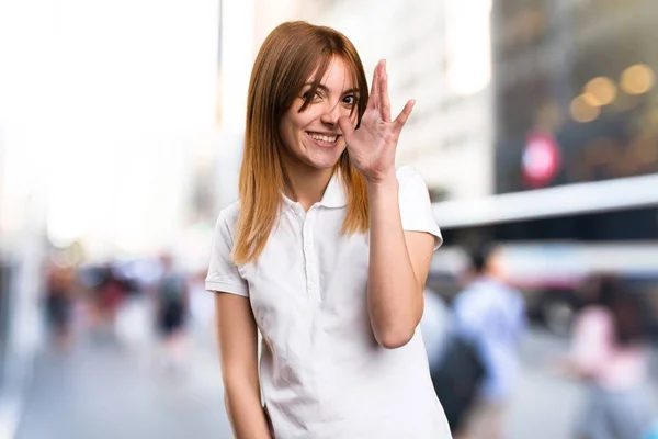 Hermosa joven haciendo una broma sobre fondo desenfocado —  Fotos de Stock