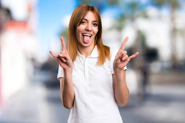 Schönes junges Mädchen macht einen Witz auf unkonzentriertem Hintergrund — Stockfoto