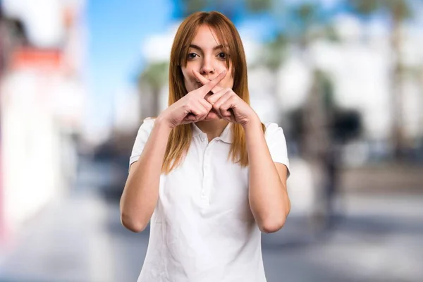 Hermosa joven haciendo gesto de silencio sobre fondo desenfocado —  Fotos de Stock