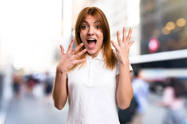 Hermosa chica joven haciendo gesto sorpresa sobre fondo desenfocado —  Fotos de Stock