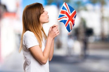 Bir Amerika Birleşik Devletleri bayrağı odaklanmamış arka planda tutan güzel genç kız