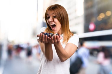 Poker fişleri odaklanmamış arka planda tutan şaşırmış mutlu güzel genç kız