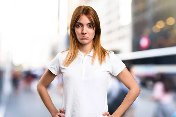 Triste joven hermosa sobre fondo desenfocado — Foto de Stock