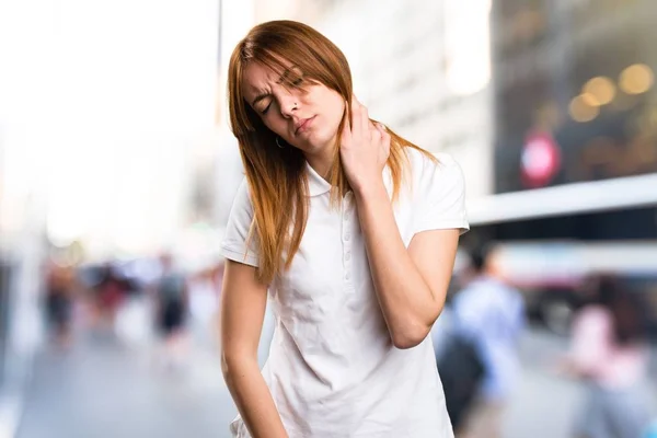 Hermosa chica joven con dolor de cuello en el fondo desenfocado — Foto de Stock