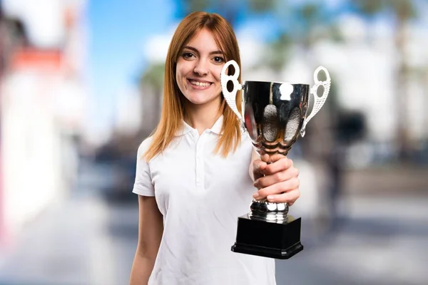 Felice Bella ragazza in possesso di un trofeo su sfondo sfocato — Foto Stock
