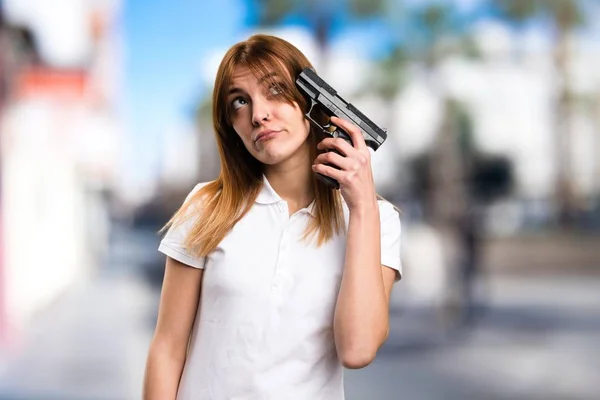 Красивая молодая девушка с пистолетом на несобранном фоне — стоковое фото