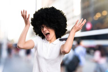 Sürpriz genç afro kız odaklanmamış arka plan üzerinde