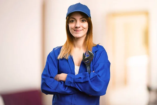 Delivery woman with her arms crossed on defocused background