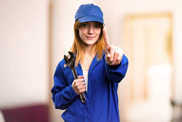 Delivery woman counting one on defocused background